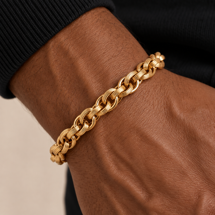 A close-up of a thick gold chain bracelet worn on a person&