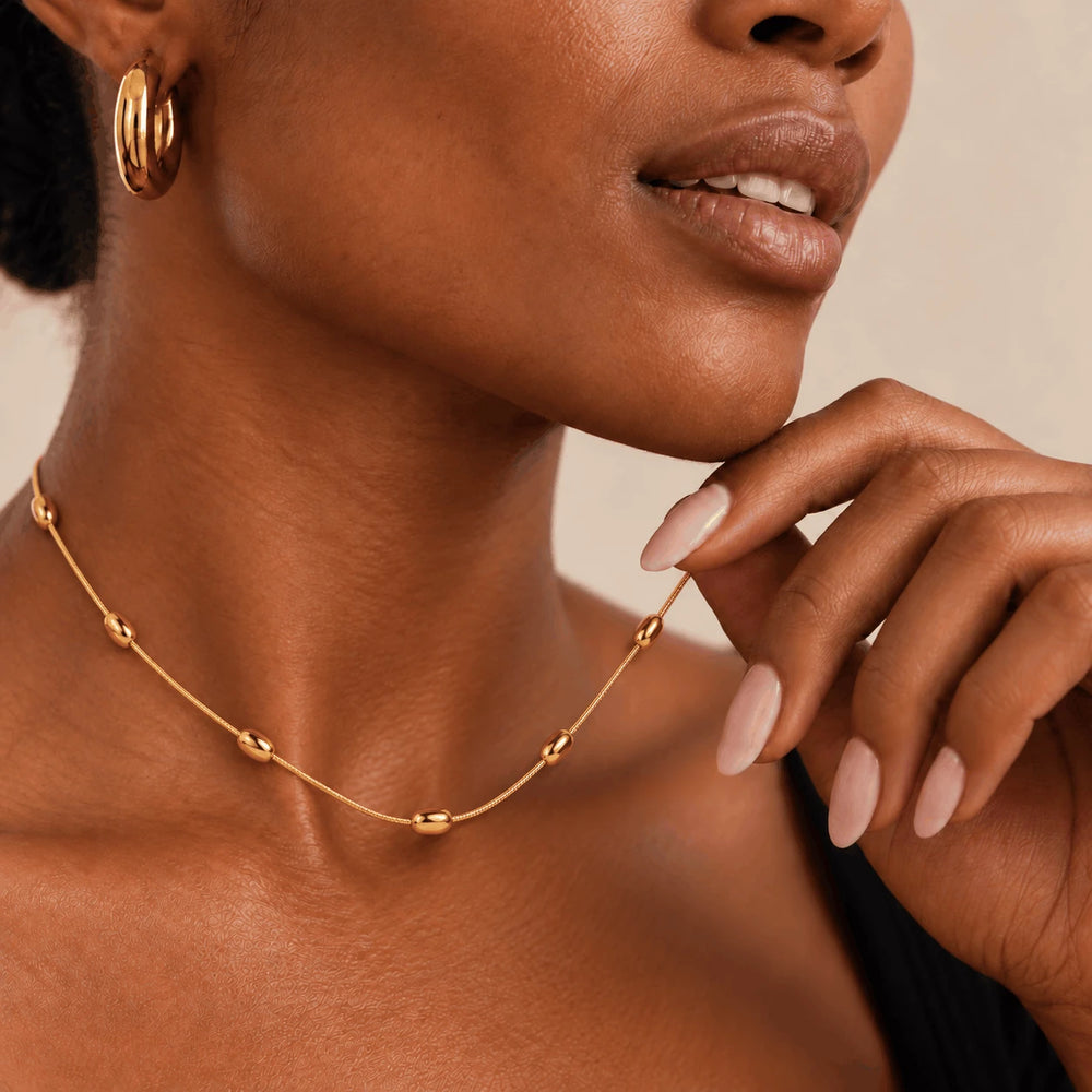 Gold Dainty Bead Necklace worn at the collarbone, close-up