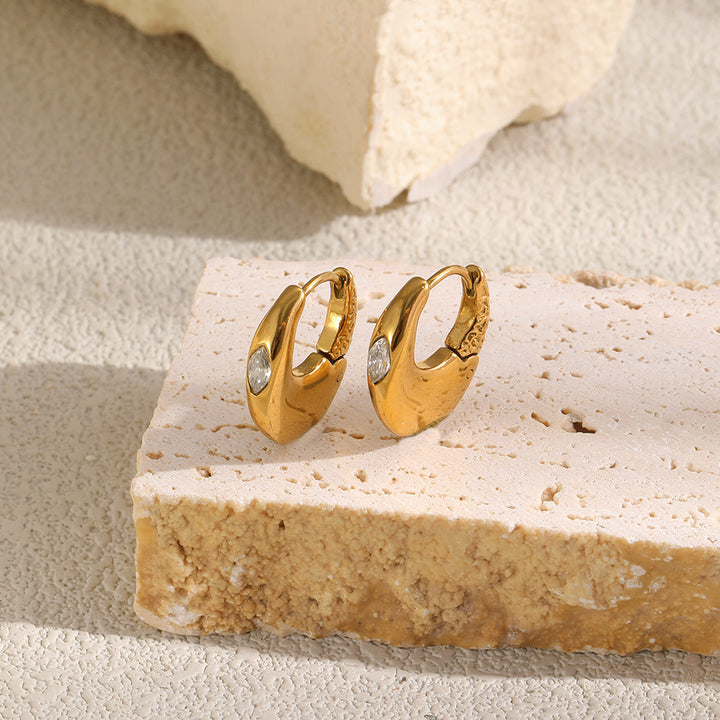 Gold Mini Solitaire Huggies standing on a stone block