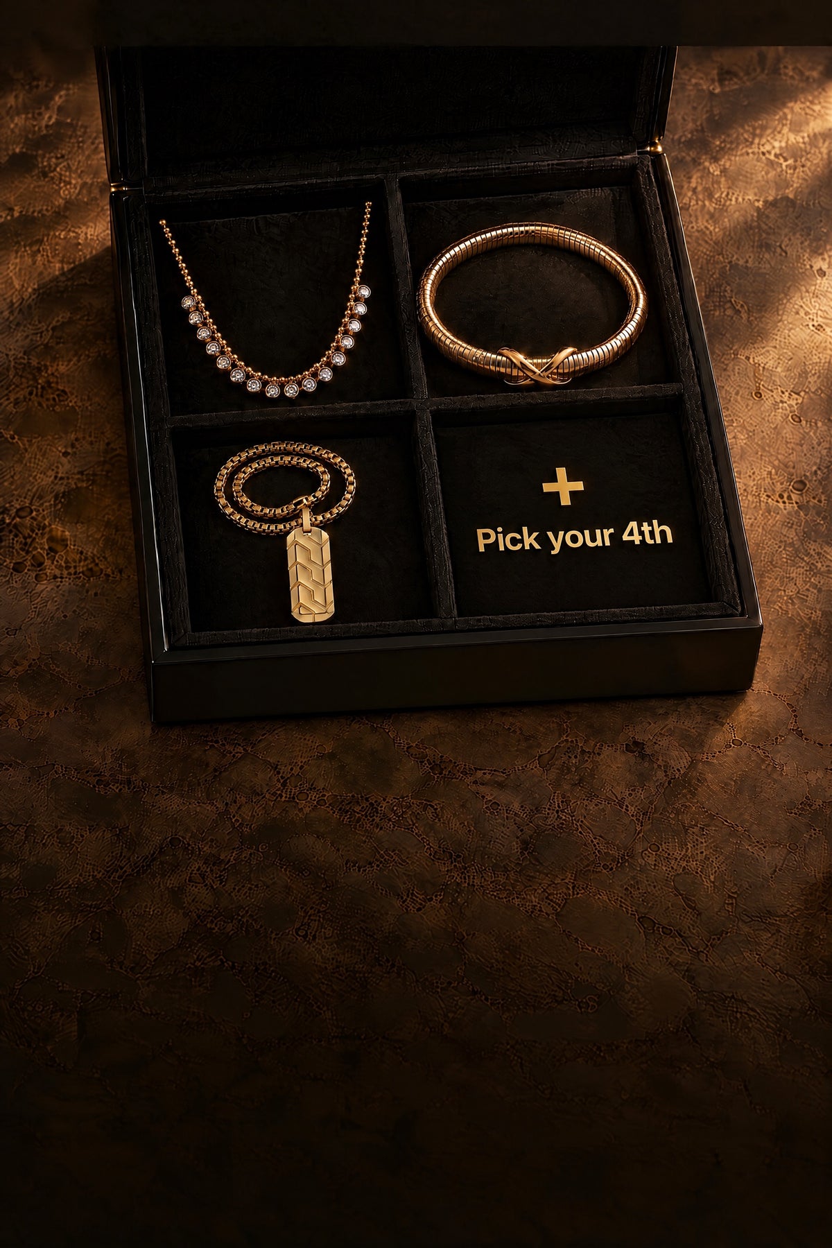 Black jewelry box with a crystal drop necklace, an infinity bangle and a men's chevron pendant, and an empty fourth slot that says Pick your 4th