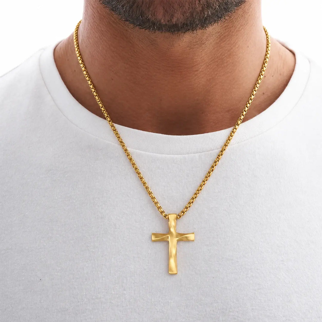 Man wearing the Gold Wavy Cross Pendant over a white T-shirt
