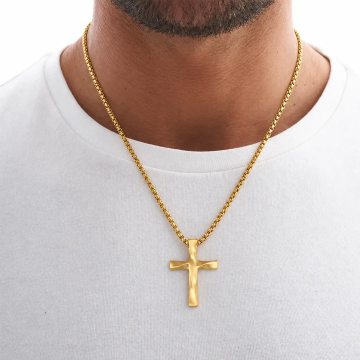 Man wearing the Gold Wavy Cross Pendant over a white T-shirt