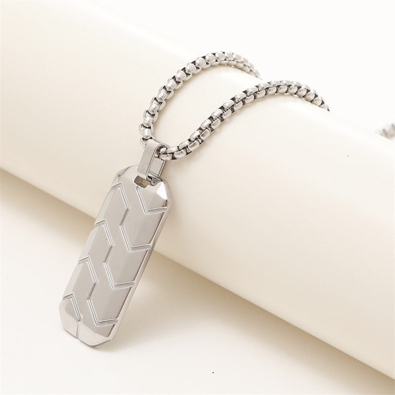 White Gold Chevron Pendant with chain draped over a white cylinder