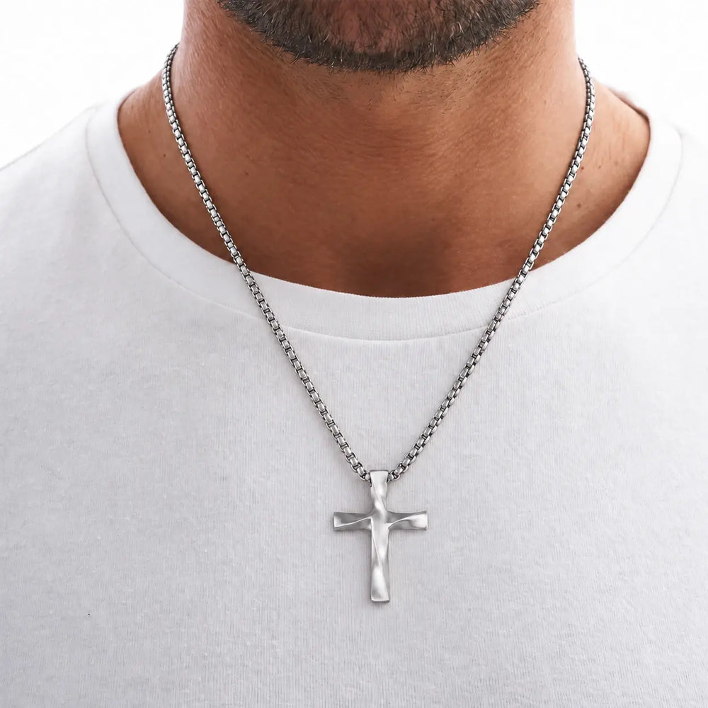 Man wearing the White Gold Wavy Cross Pendant over a white T-shirt